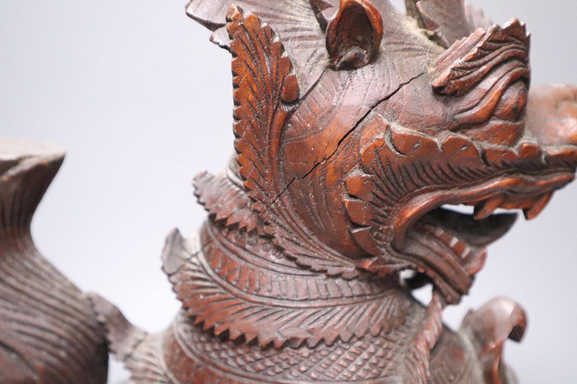An Indonesian large carved wood model of a seated kylin, on plinth base and two Chinese rootwood carvings of elders, H approx 44cm (kyl